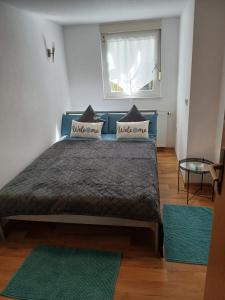 a bedroom with a blue bed with pillows and a window at Relax - Beautiful 2 rooms in Satteldorf