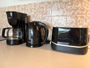 two black coffee makers and a microwave on a counter at Apartmenthaus Frauenpreiss FeWo 214 in Cuxhaven