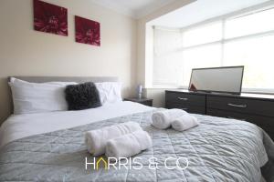 una camera da letto con un letto bianco con asciugamani sopra di Poolfoot Villas a Thornton