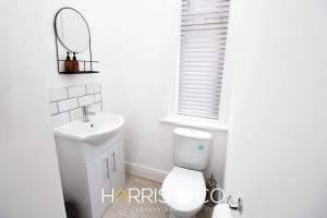 a bathroom with a toilet and a sink and a mirror at Roundtree & Berry - Fleetwood in Fleetwood +12 photos