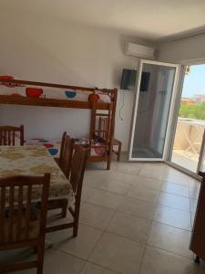 a dining room with a table and chairs and a sliding glass door at Hotel Armela in Velipojë