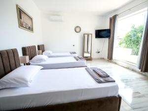 two beds in a hotel room with a tv at Daydream Villas, floor 1 in Shkodër