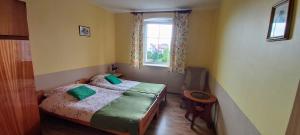 a small bedroom with a bed and a window at Dom Pod Gruszą in Chmielno