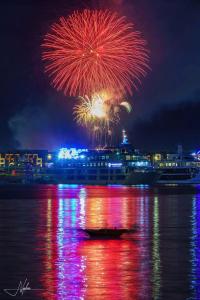un feu d'artifice au-dessus de l'eau avec un bateau de croisière dans l'établissement The Sapphire S2 Hạ Long, à Hạ Long 1 autre photo