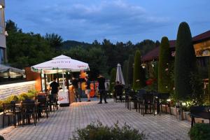 a patio with tables and chairs and an umbrella at Erta Hotel and Restaurant in Gramsh