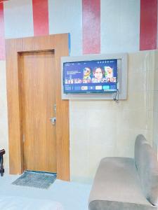 a flat screen tv on a wall next to a door at Hotel Tara Palace By MIDTOWN in Katra +7 photos