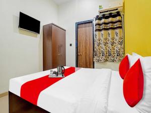 a bedroom with a red and white bed and a door at Hotel O Mauris Inn & Restaurant in Mānglia