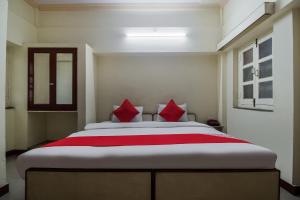una camera da letto con un letto grande con cuscini rossi di Super Hotel O Anand Hotel Jodhpur a Jodhpur