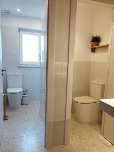 a bathroom with a toilet and a sink and a window at Endless Summer Surf House in Aljezur +37 photos