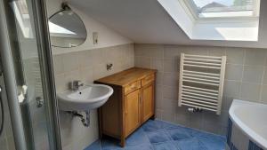 a bathroom with a sink and a mirror and a window at Chiemsee-Fewo Prien in Prien am Chiemsee