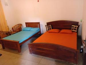une chambre avec deux lits et deux chaises dans l'établissement heritage Kalawewa holiday resort, à Balaluwewa
