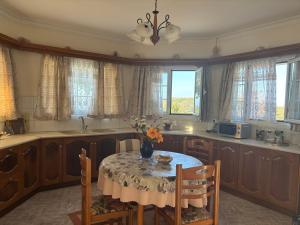 a kitchen with a table with a vase of flowers on it at Happyfield in Lixouri