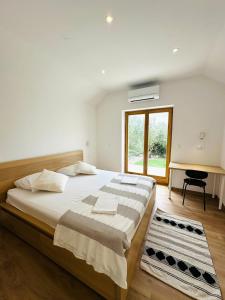 a bedroom with a large bed and a desk at Eden Holiday House with private Pool and Vineyard in Kaštela