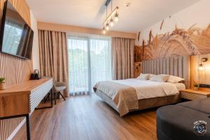 a bedroom with a bed and a desk and a couch at Ecvestria Chalet in Ocnele Mari