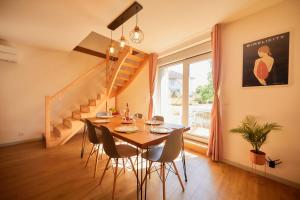a dining room with a table and chairs and a staircase at Chevilyna - cosy - calme-climatisation-jardin-animaux autorisés in Chevigny