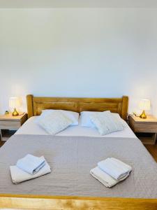 a bed with two towels on it with two lamps at Eden Holiday House with private Pool and Vineyard in Kaštela