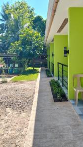 a walkway in front of a building with green walls at Malunggay's Inn in Panglao Island +4 photos
