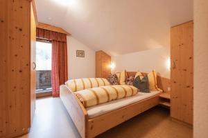 una camera da letto con un letto grande con cuscini gialli di Ferienwohnung Kirchbrücke a Mieders