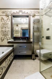 Un baño con lavabo, inodoro y espejo. en Apartamenty Magia Tatr, en Kościelisko