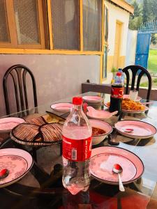 a table with plates and a bottle of water on it at 4 Season Guest House Naltar in Gilgit +4 photos