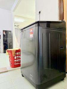 Un refrigerador negro en una habitación con una cesta roja. en Stayhouz Dlaguna- Free Netflix Wifi, en Sungai Petani 7 fotos más
