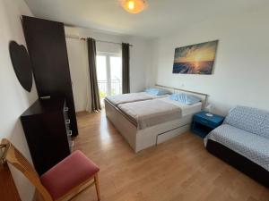 a small bedroom with a bed and a couch at Apartman Leo in Brela