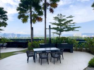 a patio with a table and chairs and palm trees at Eaton Residences KLCC - Luxury Apartment in Kuala Lumpur