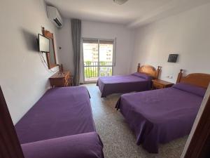 a room with two beds and a window at Hostal Susi in Peñíscola