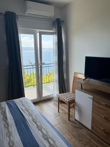 a bedroom with a bed and a balcony with a television at Apartman Leo in Brela