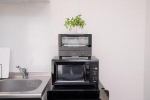 a microwave sitting on top of a kitchen counter at GLITTER202 Max 6ppl 5 minutes to USJ by train in Osaka +104 photos