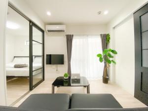 a living room with a couch and a bed at GLITTER202 Max 6ppl 5 minutes to USJ by train in Osaka