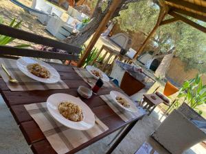 two plates of food sitting on a wooden table at Camping Ullishtja in Qeparo