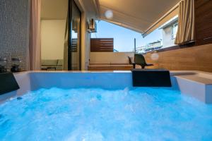 a large tub filled with blue water in a room at Dreamin Athens - Monastiraki Apartments in Athens