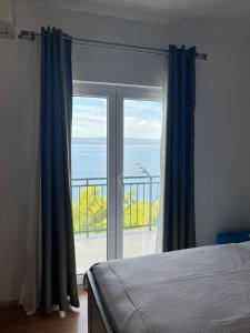a bedroom with a window with a view of the ocean at Apartman Leo in Brela