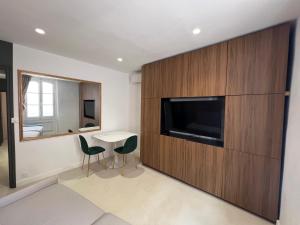 a living room with a television and a table and chairs at Nomad in Cassis
