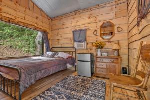 a bedroom in a log cabin with a bed and a window at Ohio Starlight Glamping Cabins - A Peaceful Woodland Retreat 
