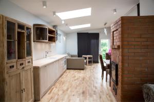 a kitchen with white cabinets and a brick wall at Allika Holiday House in Pärnu