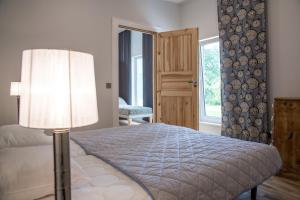 a bedroom with a bed with a lamp and a window at Allika Holiday House in Pärnu