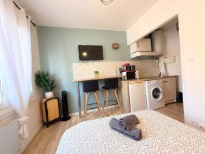 a room with a bed and a kitchen with a counter at Le Cocon Ruthenois in Rodez
