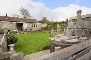 a backyard with a wooden fence and a lawn at Hare Cottage in Finghall