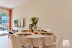 una sala da pranzo con tavolo e vaso di fiori di Casalfas - Élégance, Piscine, Emplacement idéal by LG Home conciergerie a Alfaz del Pi