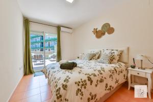 una camera da letto con un letto e una grande finestra di Casalfas - Élégance, Piscine, Emplacement idéal by LG Home conciergerie a Alfaz del Pi