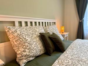 een bed met kussens erop in een slaapkamer bij Ravine Apartments - Parking in Brno