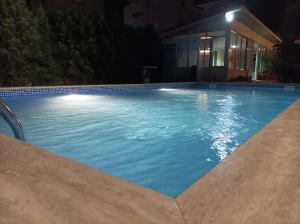 a large blue swimming pool at night at Sunny House in Kranevo