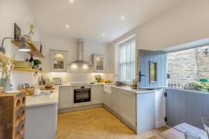 a kitchen with white cabinets and a large window at Wayside in Carperby
