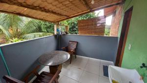a balcony with a table and chairs on a house at Casa do Carlos - Boipeba in Ilha de Boipeba +1 photo
