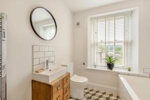 a white bathroom with a sink and a mirror at Wayside in Carperby +19 photos
