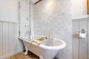 a white bathroom with a tub and a shower at 1 Browcote Cottage in Ravenscar +40 photos