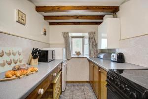 eine Küche mit einer Theke mit Brot darauf in der Unterkunft West Cottage in Thwaite