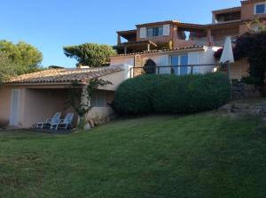 a house with two lawn chairs and an umbrella at Santa Giulia in La Celle-sous-Gouzon